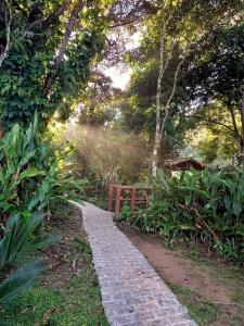 a stone path in a garden with a wooden fence at Repousada Sana in Sana
