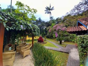 a garden with chairs and trees and a house at Repousada Sana in Sana