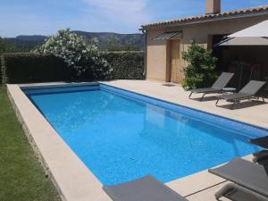 a swimming pool with blue water in a yard at Luxury villa with private swimming pool in Malaucène