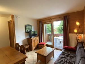 a living room with a couch and a table and a television at Appartement Les Saisies, 3 pièces, 6 personnes - FR-1-293-356 in Hauteluce