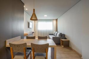 - une salle à manger et un salon avec une table et des chaises dans l'établissement Golden Laghetto Resort Gramado, à Gramado