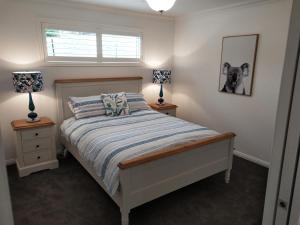 1 dormitorio con 1 cama y 2 lámparas en las mesas en Towac Valley Cabins, en Orange