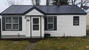 una casa bianca con tetto nero e porta di The Cozy Idaho Gem 