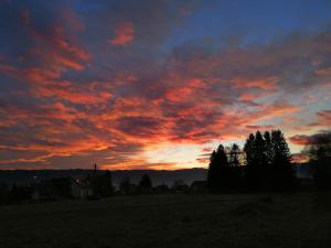 zachód słońca na polu z drzewami i chmurami w obiekcie Freya w mieście Lesce