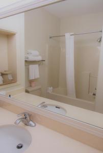 uma casa de banho com um lavatório e um espelho grande em Stay Inn & Suites Montgomery em Montgomery
