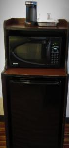 a microwave sitting on top of a wooden stand at Stay Inn & Suites Montgomery in Montgomery