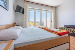 a bedroom with a large bed with a window at Apartments Laura in Dramalj
