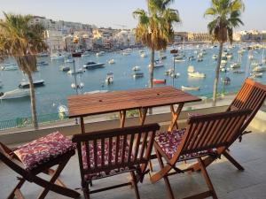 a table and two chairs with a view of a harbor at Aquamarine Sea Front Apartments - Second Floor in Marsaskala