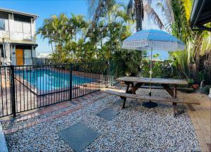 a patio area with a pool and lawn chairs at Coolangatta YHA Backpackers in Gold Coast