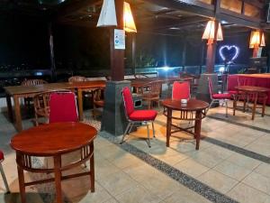 a restaurant with wooden tables and red chairs at Alfa Resort Hotel and Conference in Puncak