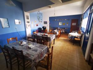 a dining room with tables and chairs and blue walls at Nikos Hotel in Diafani