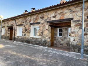 a stone building with three windows and a street at Sierra Norte in Canencia