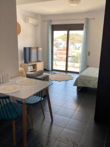 uma sala de estar com uma mesa e cadeiras e uma cama em Studio Marika em Agios Nikolaos