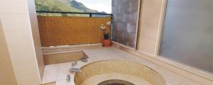 un ampio bagno con una grande finestra e una vasca di Hotspring World Wulai a Wulai
