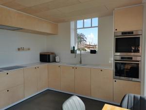 a kitchen with white cabinets and a large window at Sint-Sixtus 99 in Poperinge