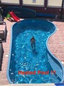 a man in a heated pool in a swimming pool at Apartments Villa Stella Maris in Rogoznica