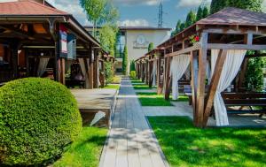 une passerelle devant un bâtiment avec des abris en bois dans l'établissement Pensiunea Iristar, à Fălticeni