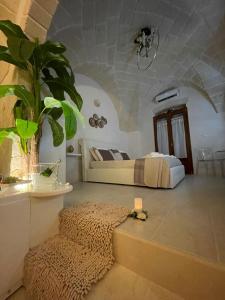 Suite il Vicoletto في Crispiano: غرفة نوم بسرير وزرع في غرفة