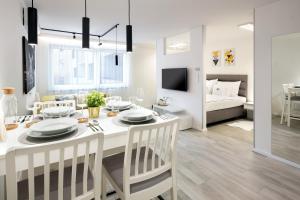 a dining room and living room with a table and chairs at Divat Apartments - Central Smart Homes in Győr