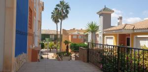 a walkway between two houses with palm trees at Apartamento Bonalba, Golf, Playas y Piscinas in Mutxamel
