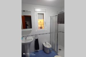 y baño con 2 lavabos, ducha y espejo. en Apartamento cabañiles wifi, en Jerez de la Frontera