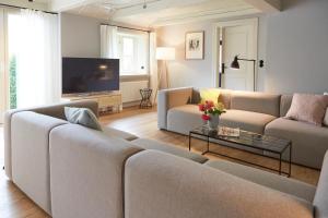 Mein Nordstern في Humptrup: غرفة معيشة مع كنبتين وتلفزيون بشاشة مسطحة