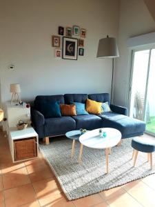 - un salon avec un canapé bleu et une table dans l'établissement T3 duplex lumineux en centre-ville (plage à 10mn), à Soustons