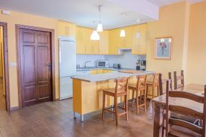 a kitchen with yellow cabinets and a table and chairs at Casa en el pantano de Orellana in Orellana la Sierra