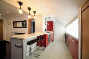 a kitchen with red cabinets and a red refrigerator at NUEVO 8 minutos ayuntamiento, 10 catedral, WIFI in Oviedo