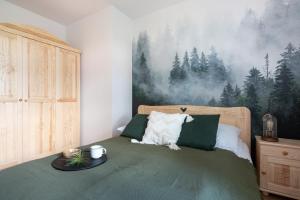 扎科帕內的住宿－Prestige Apartamenty Przy Potoku Centrum，卧室配有一张壁挂森林壁画的床