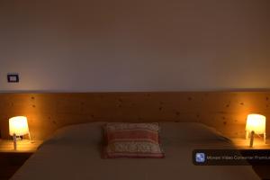 a bedroom with a bed with two lamps on it at Casa Acquariana in Belluno