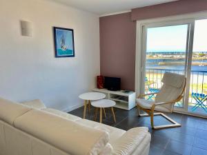 a living room with a white couch and a balcony at Superbe studio face mer in Pornichet