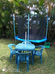 a blue table with two chairs and a trampoline at Charmant studio dans le sud, idéal pour un couple in Trois Mares-les Hauts
