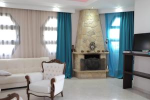 ein Wohnzimmer mit einer weißen Couch und einem Kamin in der Unterkunft Irenes Apartment in Kallithea (Chalkidiki)