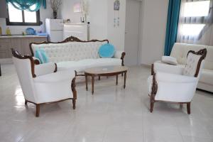 uma sala de estar com um sofá e duas cadeiras e uma mesa em Irenes Apartment em Kallithea Halkidikis