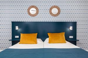 Cotillo House في كوتيو: سرير مع وسادتين برتقاليتين في غرفة النوم