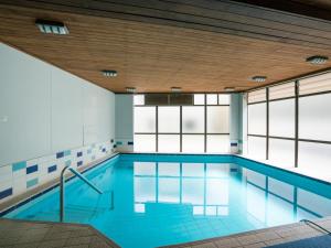 una piscina con agua azul y ventanas en Ika Nui Taupo en Taupo