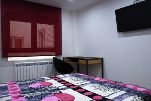 1 dormitorio con cama, escritorio y ventana en RECOMENDADO: Wifi+ 12 min ayto + 4 habs dobles + PARKING, en Oviedo