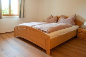 a bed with a wooden frame in a bedroom at Ferienwohnung Stefanie in Bad Mitterndorf