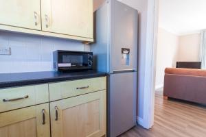 a kitchen with a microwave and a refrigerator at Cosy Brixham apartment with garden close to Town in Brixham