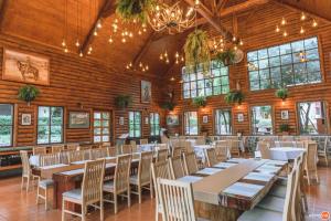 a dining room with tables and chairs in a building at Plakan Resort in Kanchanaburi