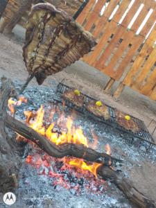 a grill with some food on top of it at Munay EcoHostal - Cabañas de Adobe in Tinogasta