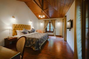a bedroom with a large bed in a room at WelcomHeritage Ashdale in Nainital +53 photos