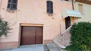 a building with a brown door and a staircase at Corte Manzoglio in Gazzuolo