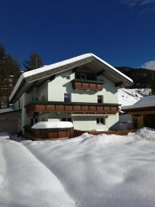 una casa con nieve en el suelo delante de ella en Sand 4, en Stanzach