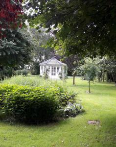 a small white house in the middle of a field at Romantik og idyl in Dybvad