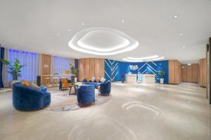 una grande hall con sedie blu e un tavolo di Holiday Inn Express - Harbin Songbei New District, an IHG Hotel a Harbin