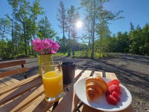 Pointe-du-Chêne的住宿－Maplebrook Retreat，一张桌子,上面放着一盘食物和一杯橙汁