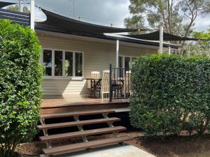 a porch of a house with a table and chairs at Miss Bullens Cottage in Yungaburra