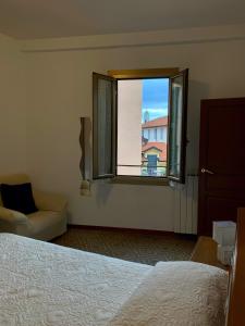 um quarto com uma cama e uma janela em Casa Dei Nonni em Sanremo